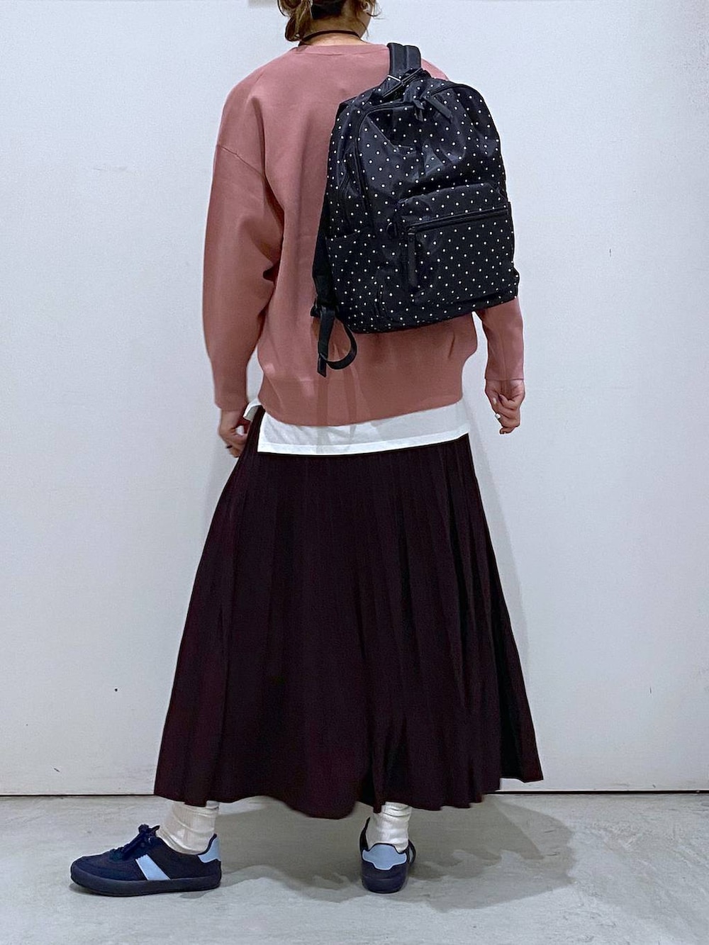 ブルー系のスニーカー、ピンク系のスウェット、ブラウン系のスカートを着用したレディースの秋コーディネートの3枚目の写真