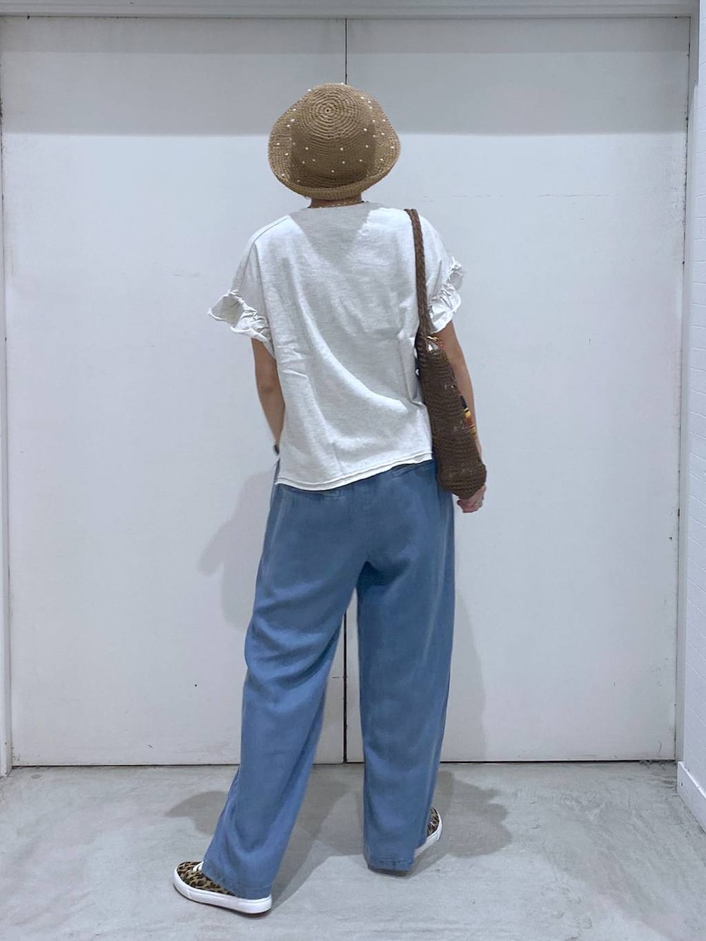 その他のスニーカー、ブルー系のデニムパンツ、ブラウン系のトートバッグを着用したレディースの春コーディネートの4枚目の写真
