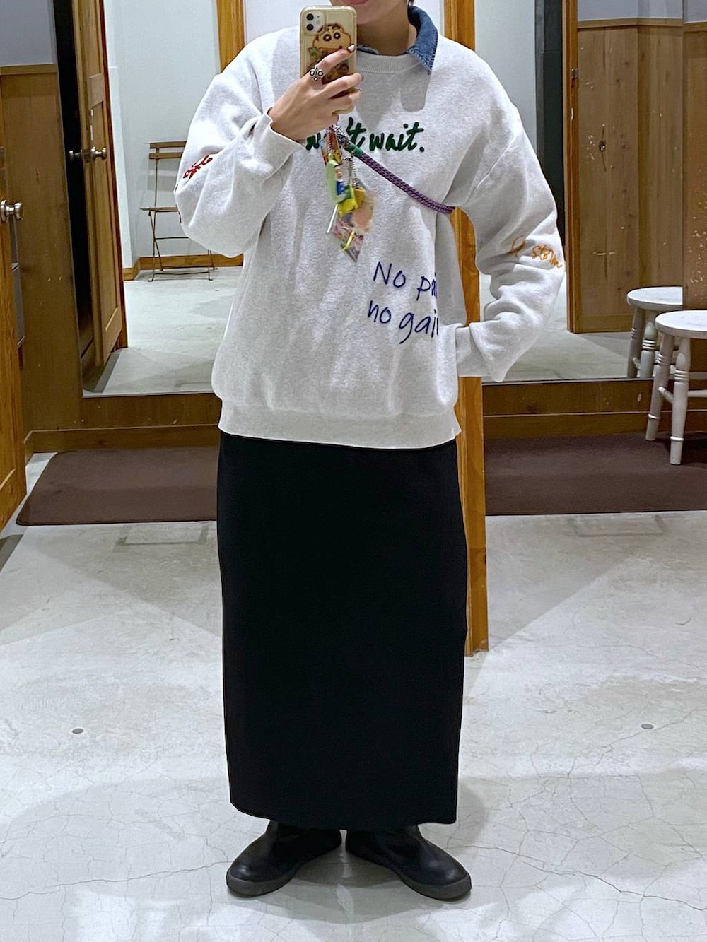 グレー系のワンピース、ブラック系のブーツ、ブルー系のシャツ/ブラウスを着用したレディースの冬コーディネートの2枚目の写真