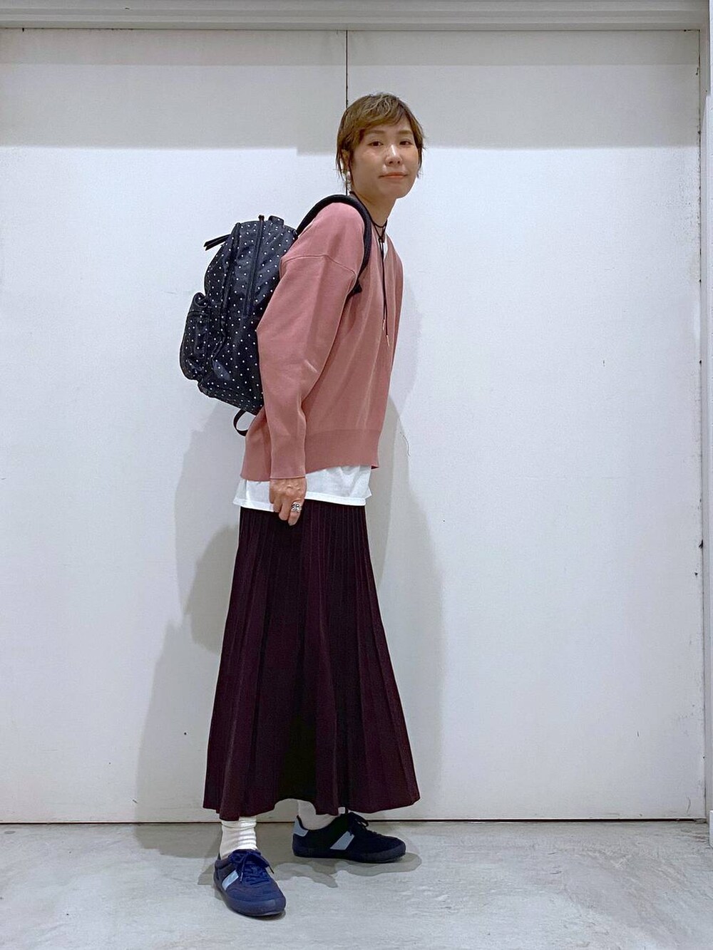 ブルー系のスニーカー、ピンク系のスウェット、ブラウン系のスカートを着用したレディースの秋コーディネートの4枚目の写真