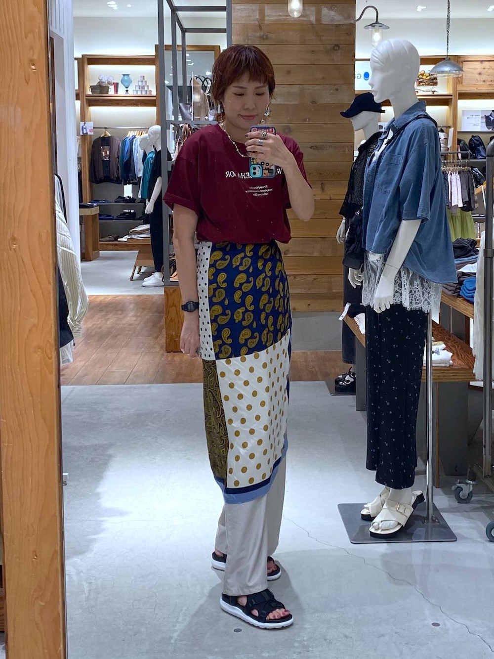 ベージュ系のその他パンツ、レッド系のTシャツ/カットソー、ブラック系のサンダルを着用したレディースの夏コーディネートの3枚目の写真