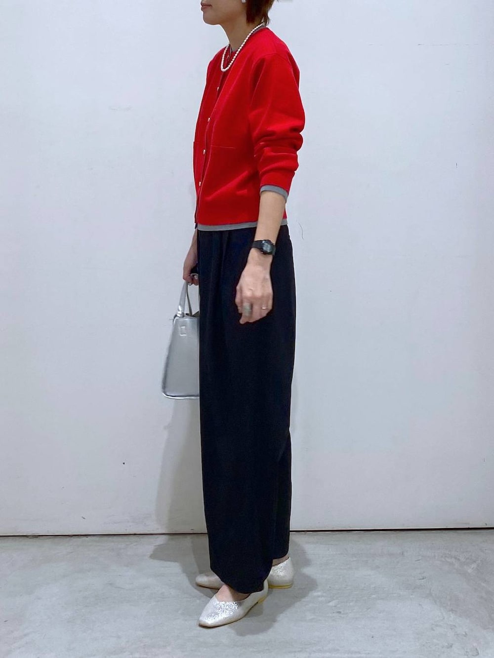 シルバー系のパンプス、シルバー系のトートバッグ、レッド系のカーディガン/ボレロを着用したレディースの春コーディネートの4枚目の写真