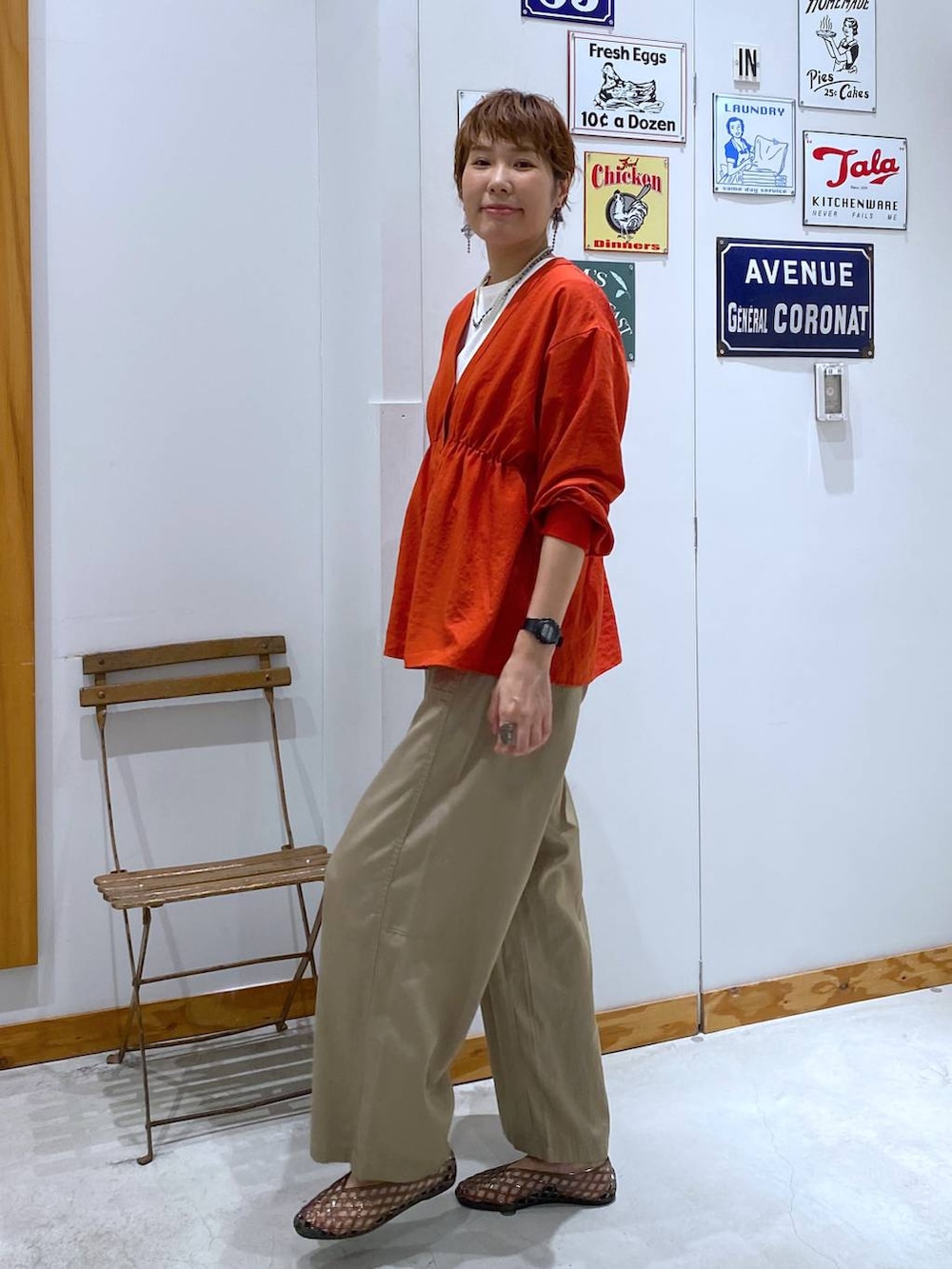 オレンジ系のシャツ/ブラウス、その他のショルダーバッグ、ベージュ系のその他パンツを着用したレディースの夏コーディネートの2枚目の写真