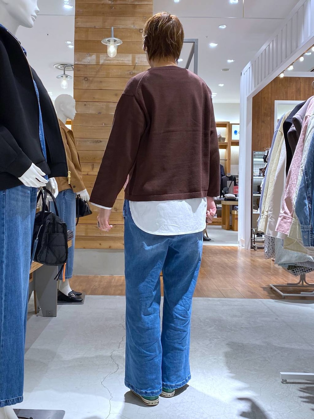 ブルー系のデニムパンツ、ブラウン系のニット/セーターを着用したレディースの冬コーディネートの2枚目の写真