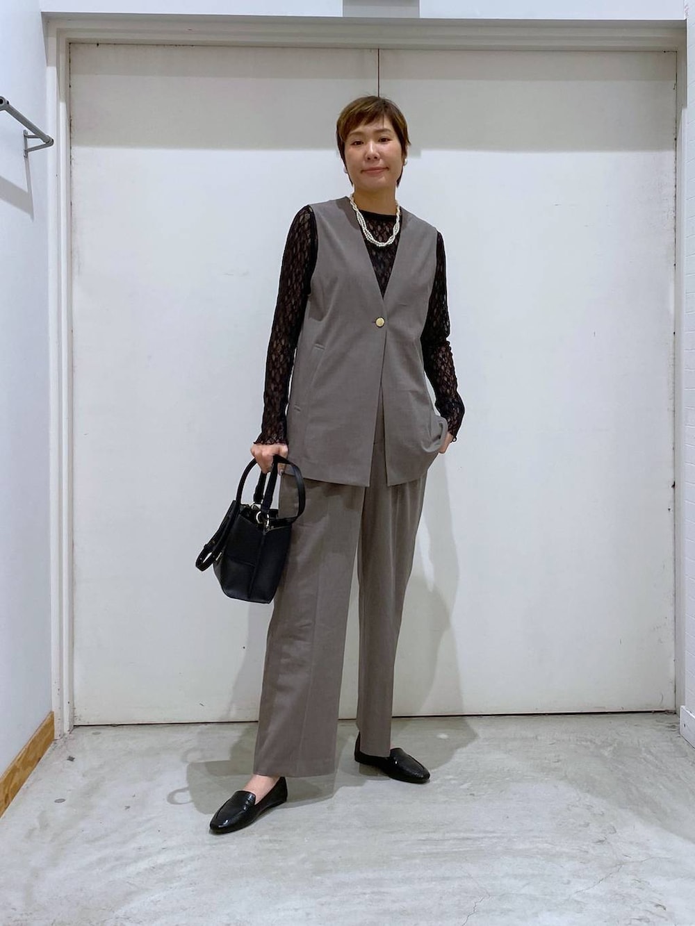 ブラック系のその他シューズ、ブラック系のTシャツ/カットソー、ブラウン系のスラックスを着用したレディースの春コーディネートの7枚目の写真