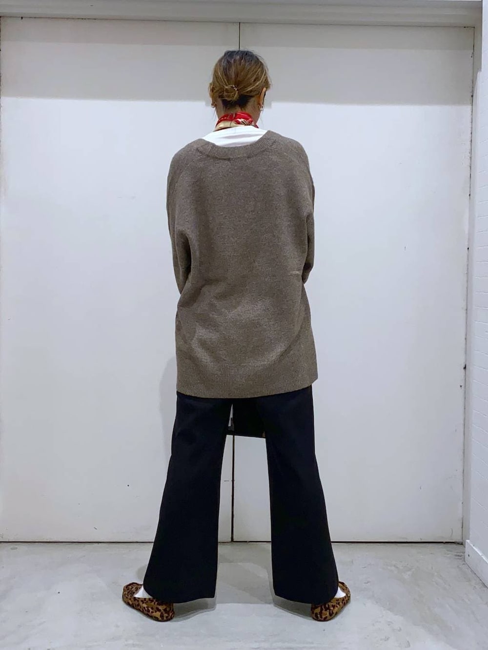 ブラウン系のニット/セーター、ホワイト系のTシャツ/カットソー、ブラック系のボストンバッグを着用したレディースの冬コーディネートの3枚目の写真