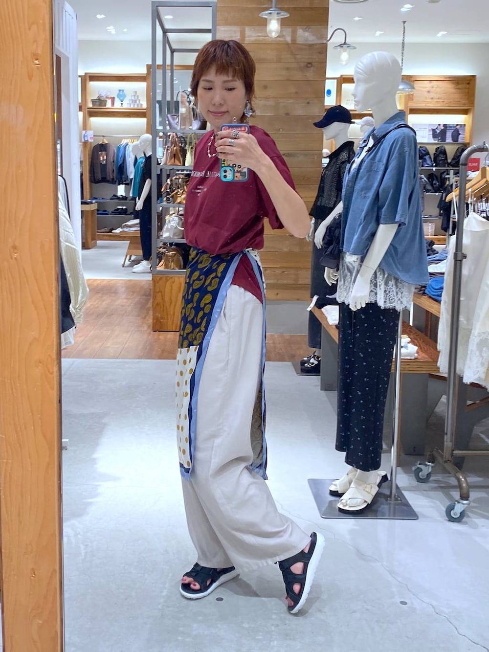 ベージュ系のその他パンツ、レッド系のTシャツ/カットソー、ブラック系のサンダルを着用したレディースの夏コーディネートの2枚目の写真