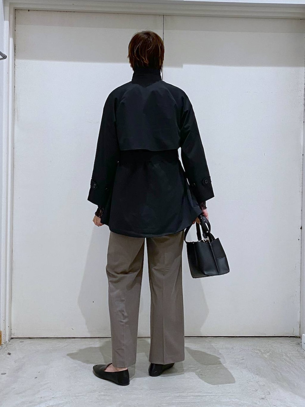 ブラック系のその他シューズ、ブラック系のTシャツ/カットソー、ブラウン系のスラックスを着用したレディースの春コーディネートの4枚目の写真