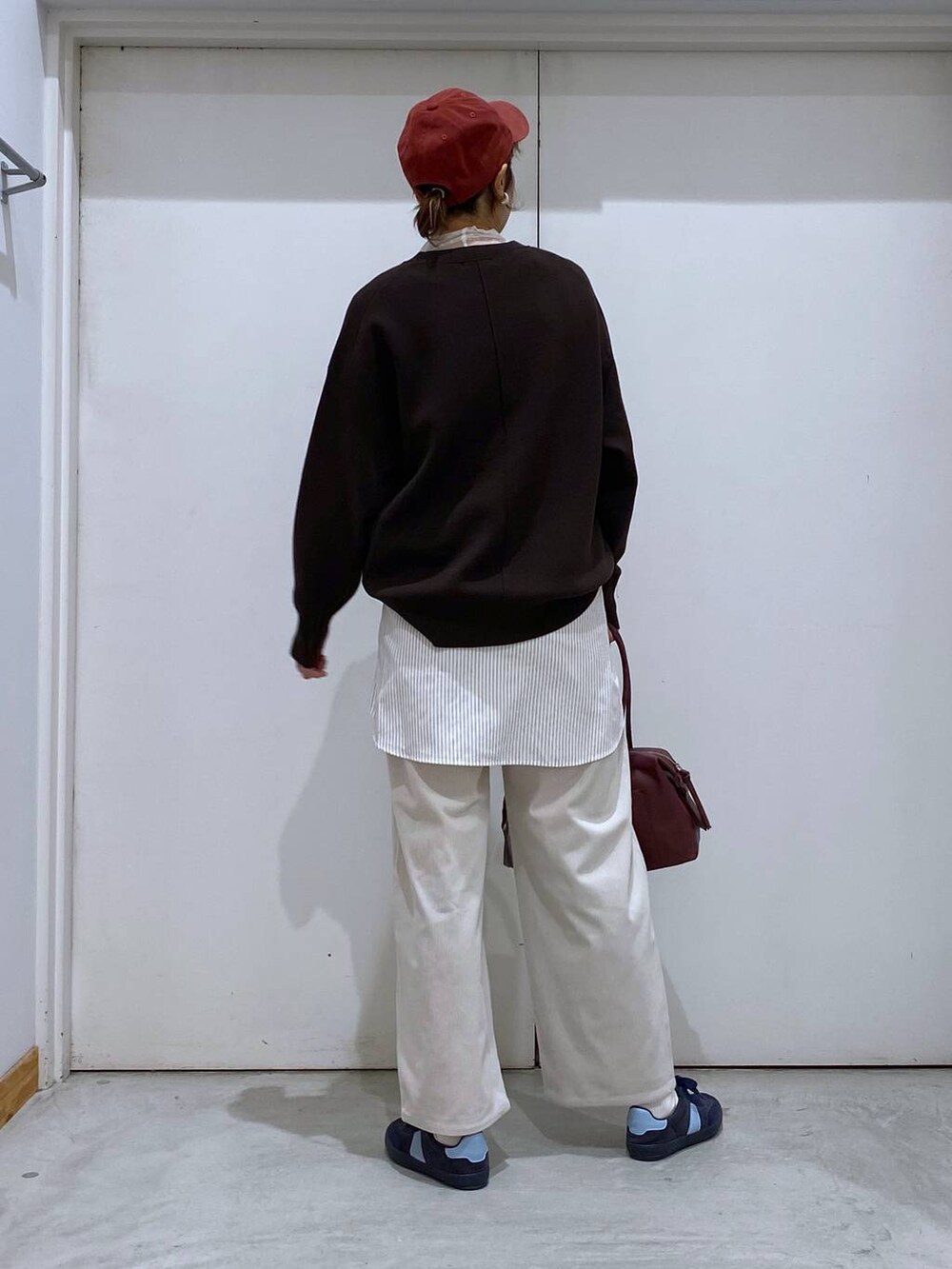 ブルー系のスニーカー、レッド系のボストンバッグ、ブラウン系のブルゾンを着用したレディースの秋コーディネートの5枚目の写真