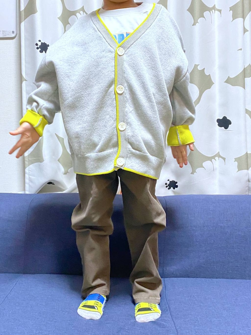 ブラウン系のデニムパンツ、グレー系のTシャツ/カットソー、グレー系のニット/セーターを着用したキッズの冬コーディネートの3枚目の写真