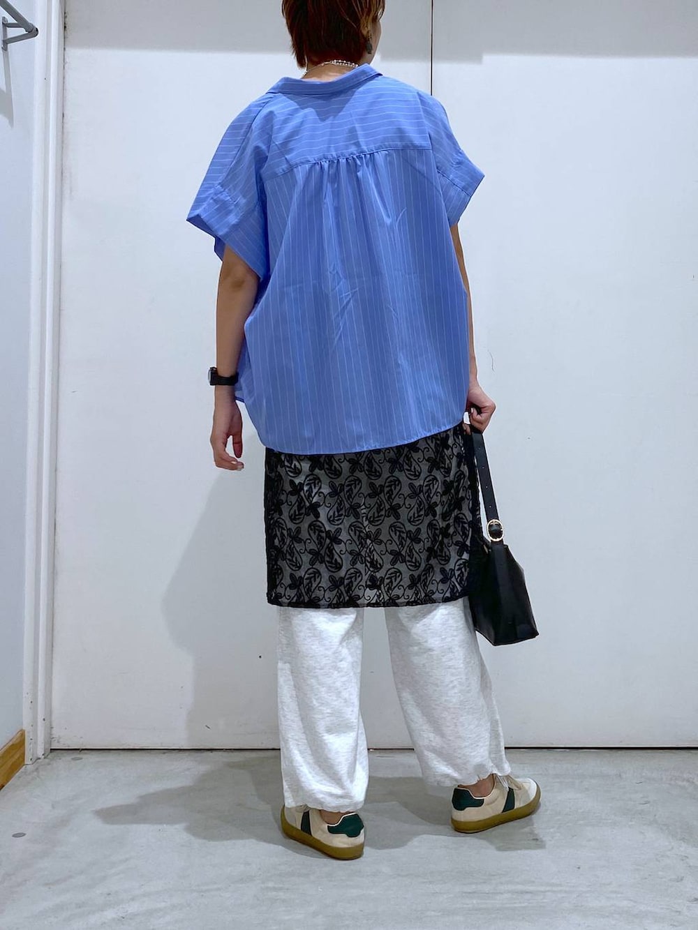 ベージュ系のスニーカー、ブラック系のショルダーバッグ、グレー系のタンクトップを着用したレディースの夏コーディネートの3枚目の写真