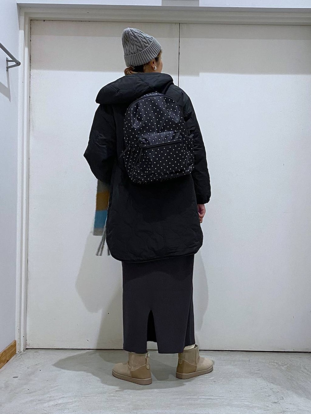 ブラック系のブルゾン、グレー系のバックパック/リュック、グレー系のワンピースを着用したレディースの冬コーディネートの3枚目の写真