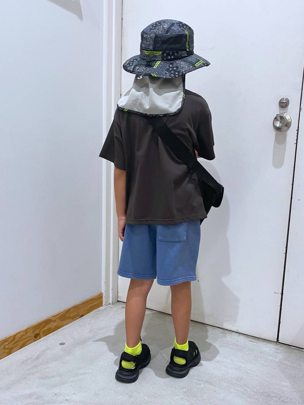 グレー系のTシャツ/カットソー、ブラック系のメッセンジャーバッグ、ブラック系のスニーカーを着用したキッズの夏コーディネートの3枚目の写真