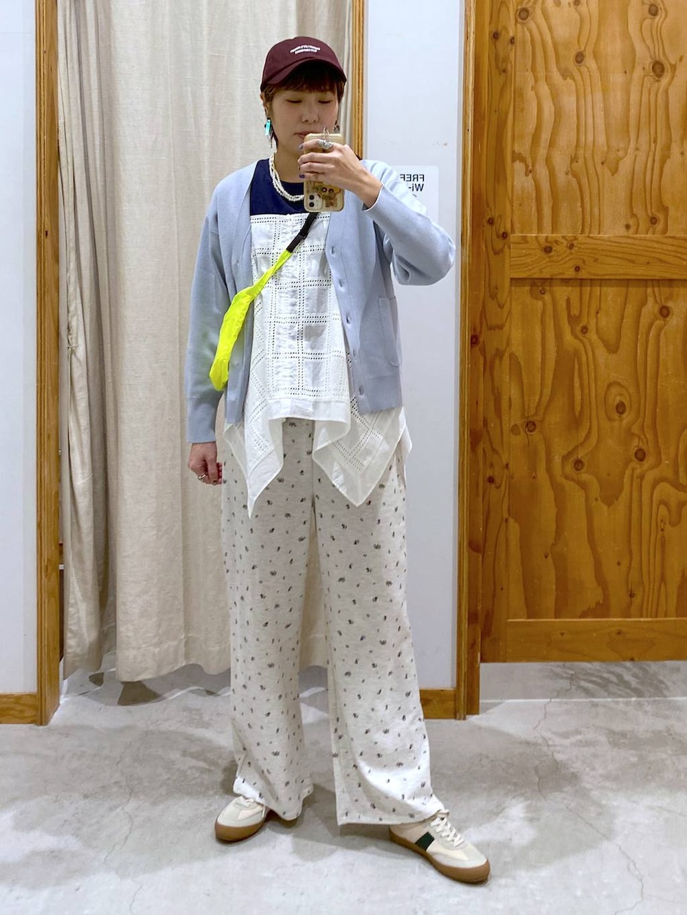 ベージュ系のスニーカー、イエロー系のショルダーバッグ、ブルー系のカーディガン/ボレロを着用したレディースの春コーディネートの2枚目の写真