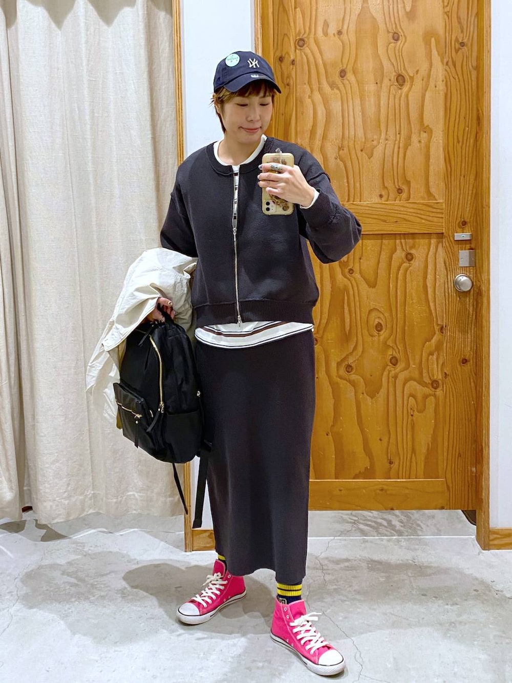 ブラック系のバックパック/リュック、イエロー系のショルダーバッグ、グレー系のワンピースを着用したレディースの春コーディネートの3枚目の写真