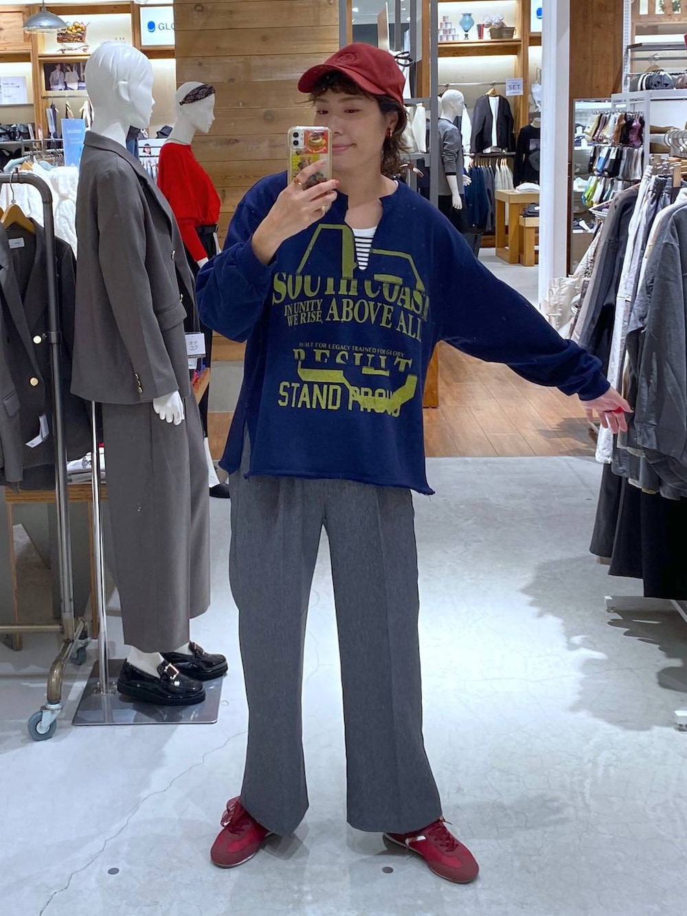 グレー系のその他パンツ、ブルー系のTシャツ/カットソー、レッド系のキャップを着用したレディースの秋コーディネートの2枚目の写真