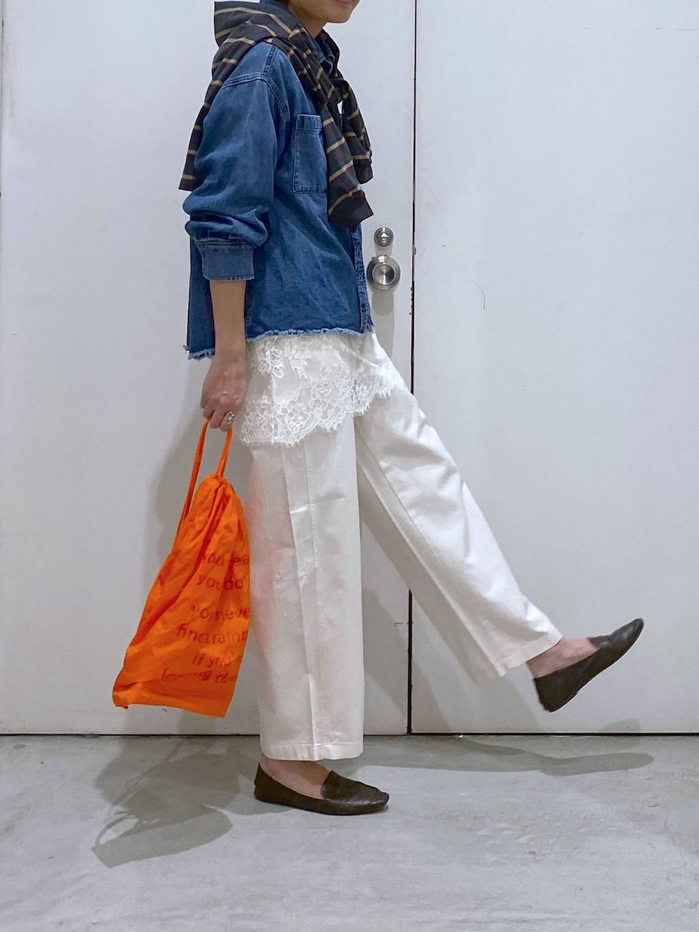 オレンジ系のバックパック/リュック、ブルー系のシャツ/ブラウス、グレー系のTシャツ/カットソーを着用したレディースの春コーディネートの4枚目の写真