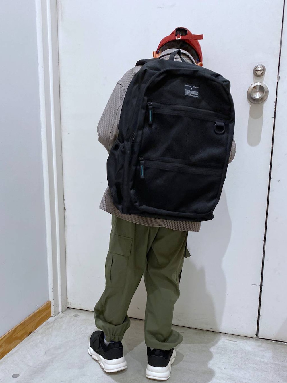 グリーン系のカーゴパンツ、ブラウン系のシャツ/ブラウス、ブラック系のバックパック/リュックを着用したキッズの秋コーディネートの4枚目の写真