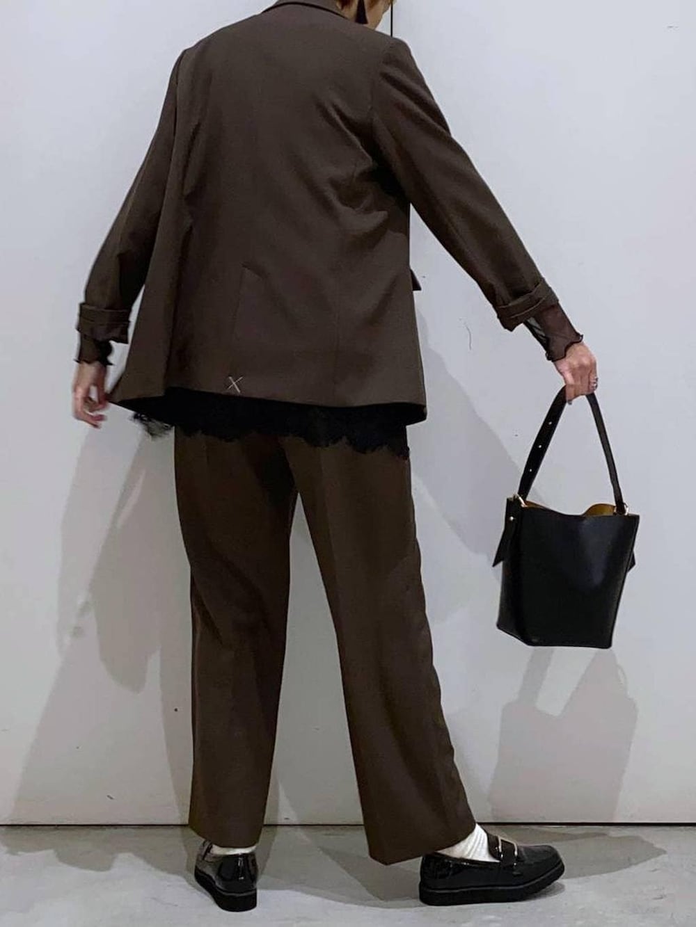 ブラック系のローファー、ブラック系のショルダーバッグ、ブラック系のTシャツ/カットソーを着用したレディースの冬コーディネートの5枚目の写真