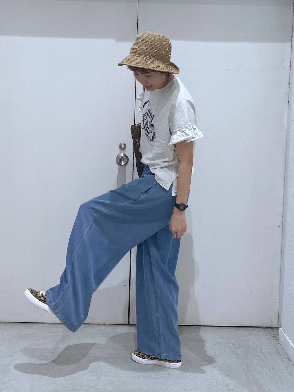 その他のスニーカー、ブルー系のデニムパンツ、ブラウン系のトートバッグを着用したレディースの春コーディネートの2枚目の写真