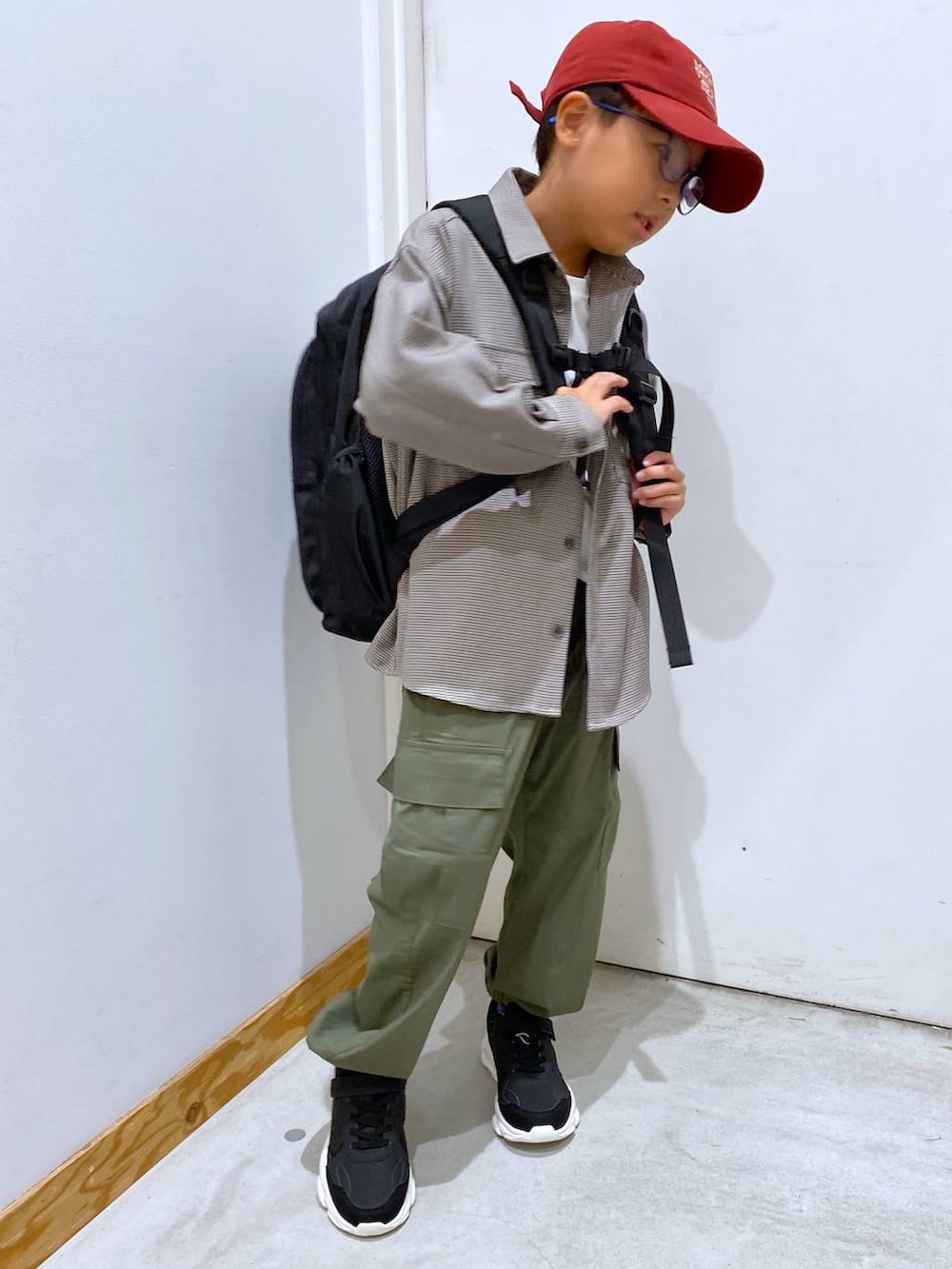 グリーン系のカーゴパンツ、ブラウン系のシャツ/ブラウス、ブラック系のバックパック/リュックを着用したキッズの秋コーディネートの5枚目の写真
