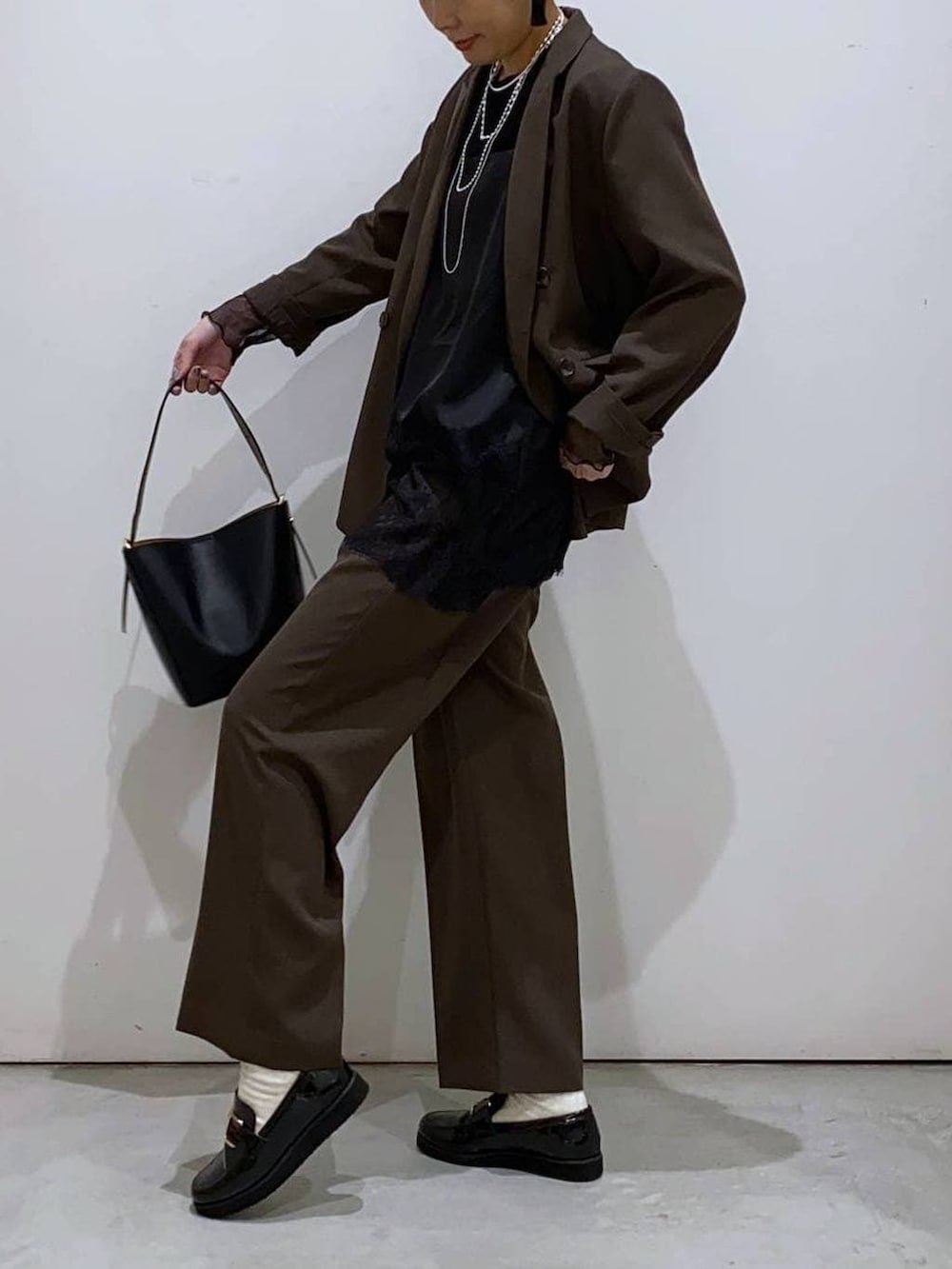 ブラック系のローファー、ブラック系のショルダーバッグ、ブラック系のTシャツ/カットソーを着用したレディースの冬コーディネートの4枚目の写真