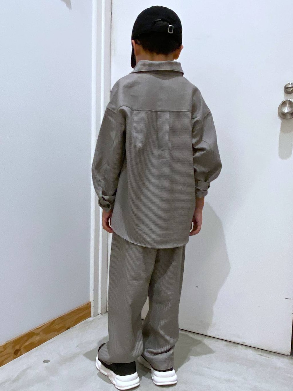 ブラウン系のその他パンツ、ブラウン系のシャツ/ブラウス、ブラック系のスニーカーを着用したキッズの秋コーディネートの4枚目の写真