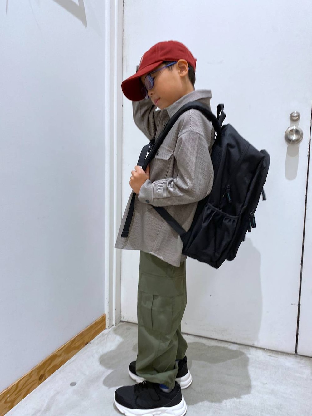 グリーン系のカーゴパンツ、ブラウン系のシャツ/ブラウス、ブラック系のバックパック/リュックを着用したキッズの秋コーディネートの3枚目の写真