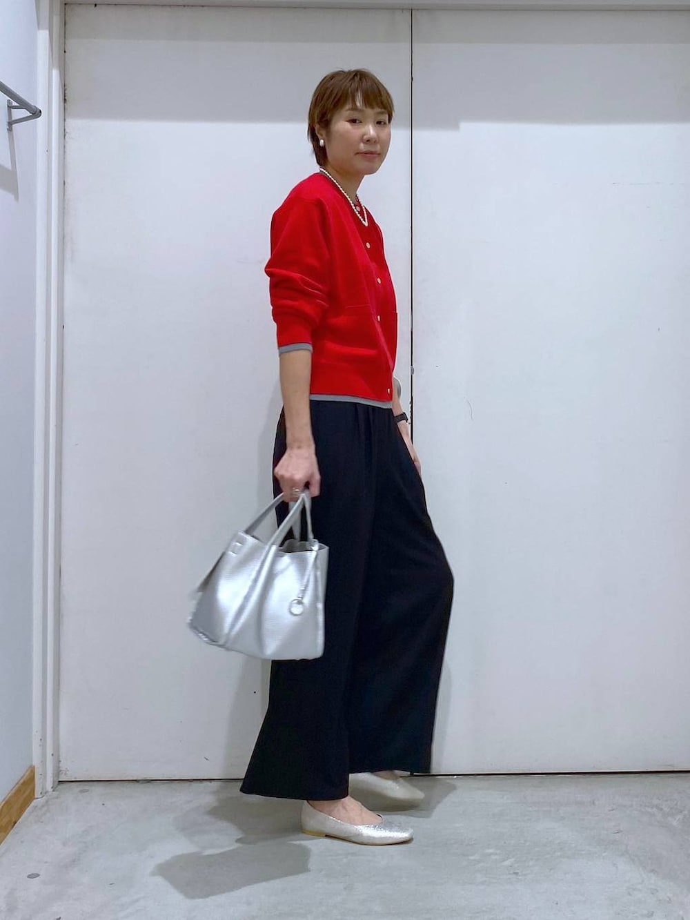 シルバー系のパンプス、シルバー系のトートバッグ、レッド系のカーディガン/ボレロを着用したレディースの春コーディネートの2枚目の写真