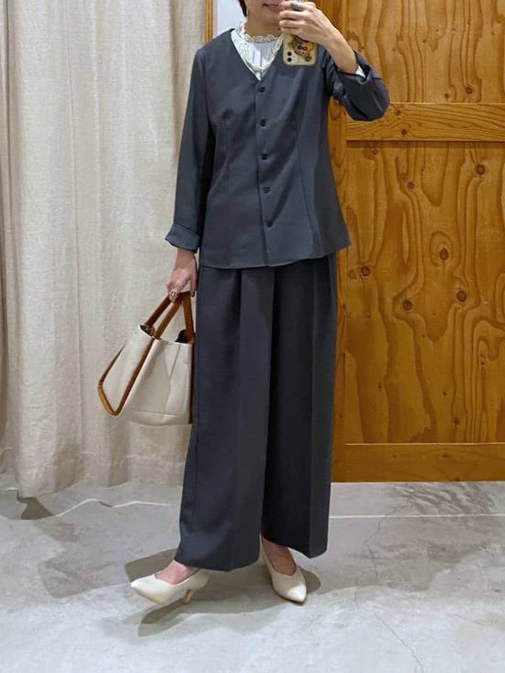 ホワイト系のパンプス、ベージュ系のトートバッグ、グレー系のシャツ/ブラウスを着用したレディースの春コーディネートの2枚目の写真