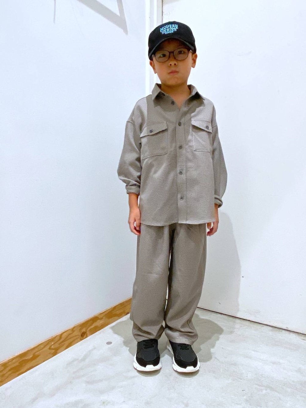 ブラウン系のその他パンツ、ブラウン系のシャツ/ブラウス、ブラック系のスニーカーを着用したキッズの秋コーディネートの2枚目の写真