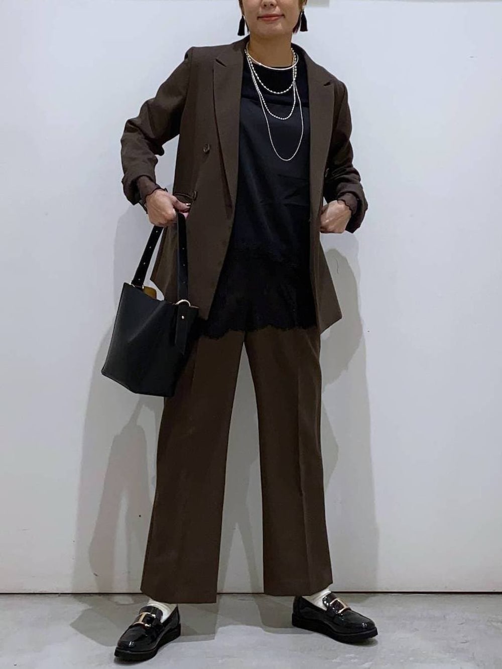 ブラック系のローファー、ブラック系のショルダーバッグ、ブラック系のTシャツ/カットソーを着用したレディースの冬コーディネートの6枚目の写真