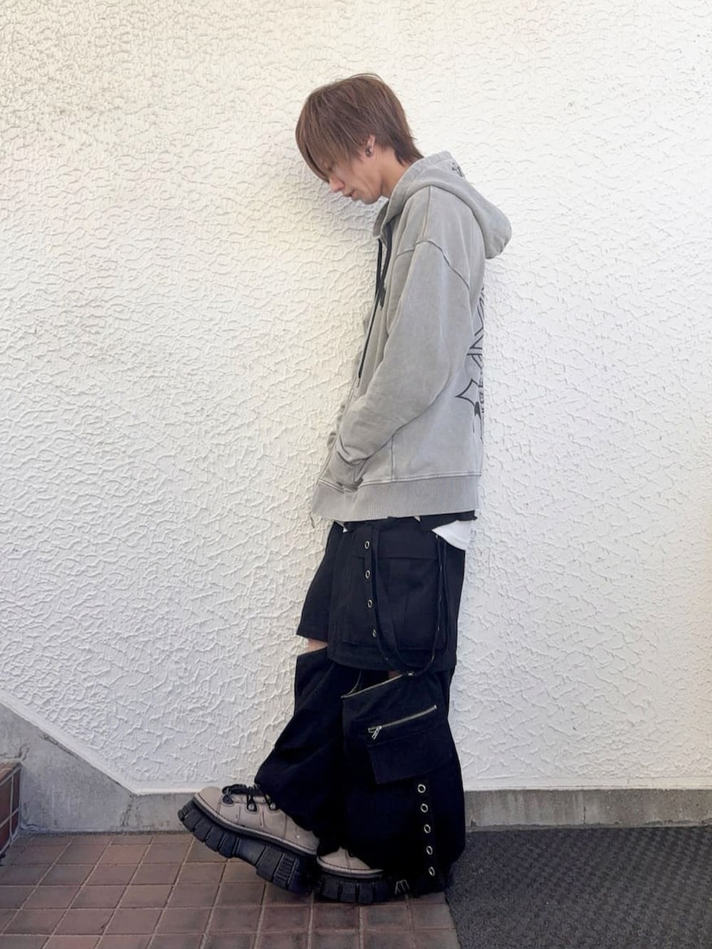 グレー系のパーカー、ブラック系のその他パンツを着用したメンズの春コーディネートの2枚目の写真