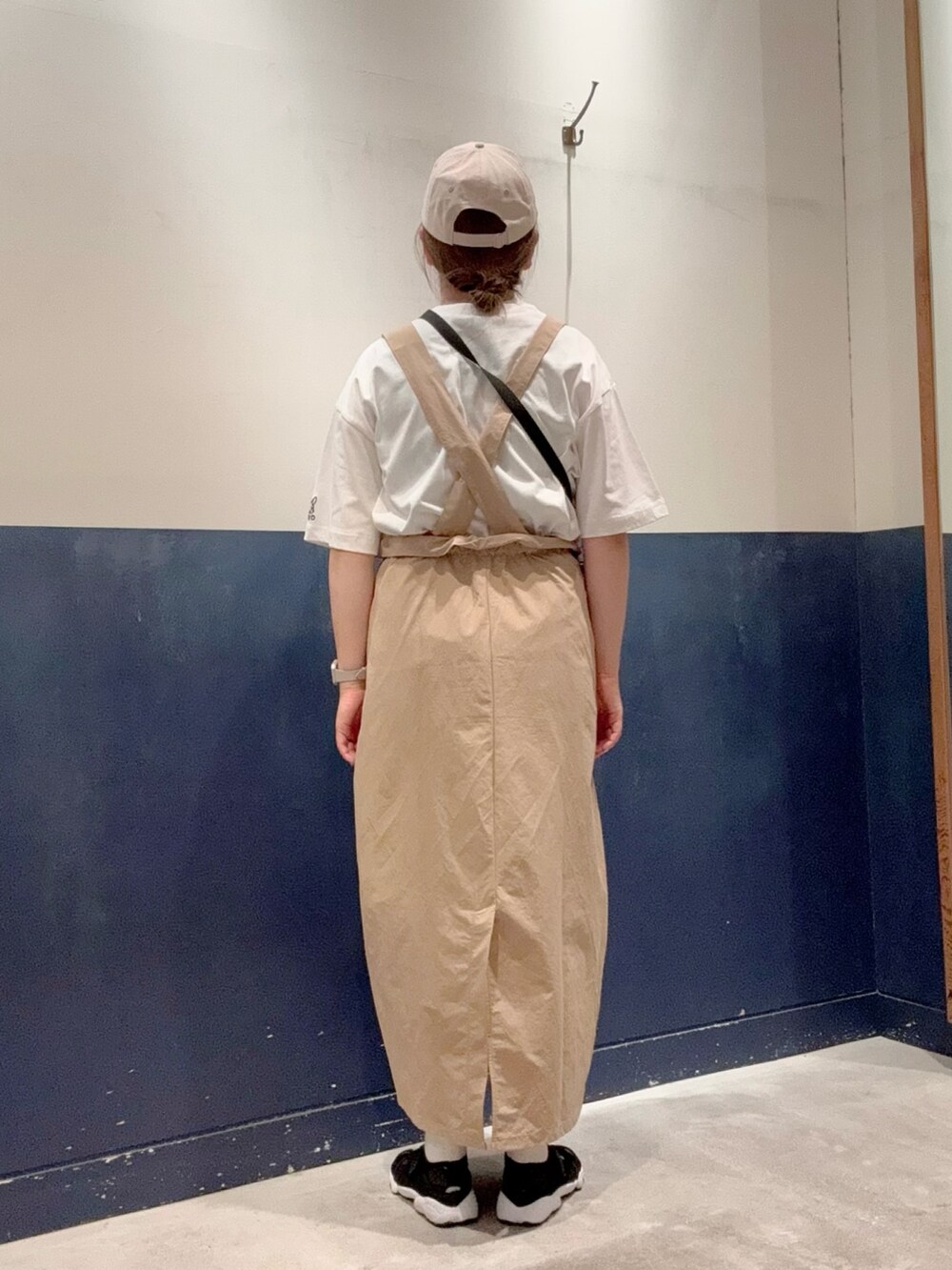 ホワイト系のTシャツ/カットソー、ブラック系のトートバッグ、ベージュ系のスカートを着用したレディースの春コーディネートの3枚目の写真