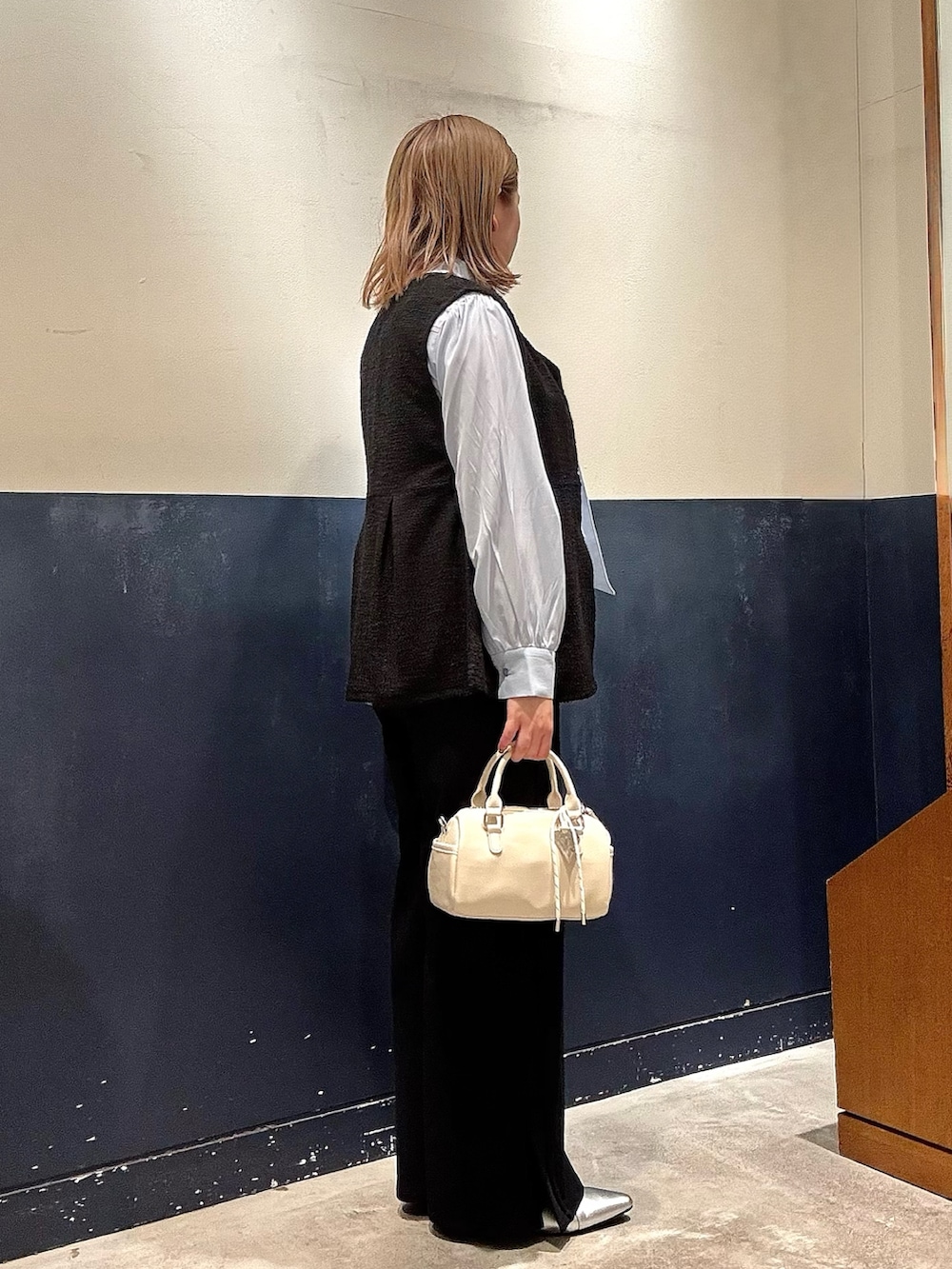 シルバー系のパンプス、ホワイト系のショルダーバッグ、ブルー系のシャツ/ブラウスを着用したレディースの冬コーディネートの2枚目の写真