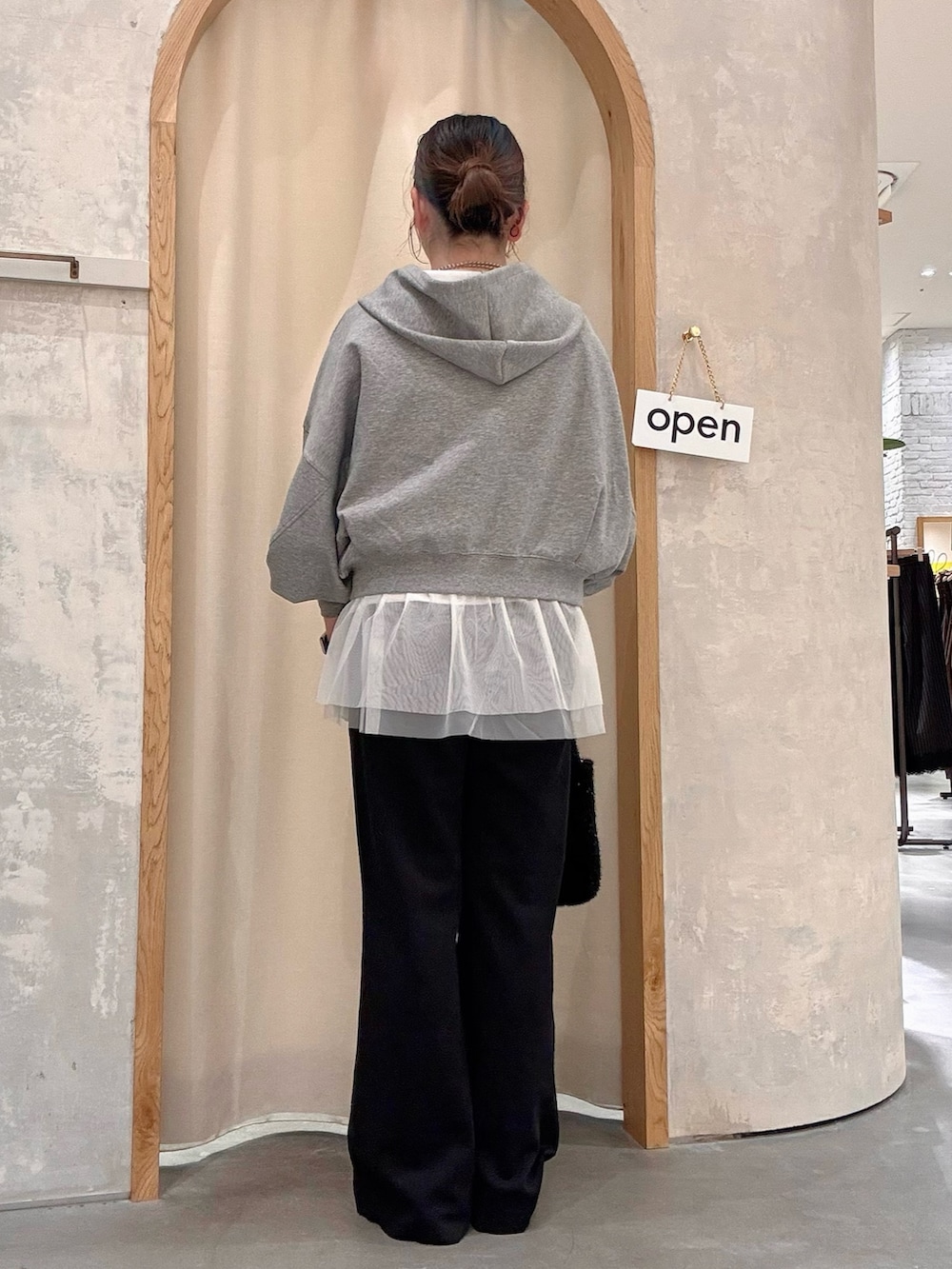 グレー系のパーカー、ブラック系のショルダーバッグ、ブラック系のその他パンツを着用したレディースの秋コーディネートの3枚目の写真
