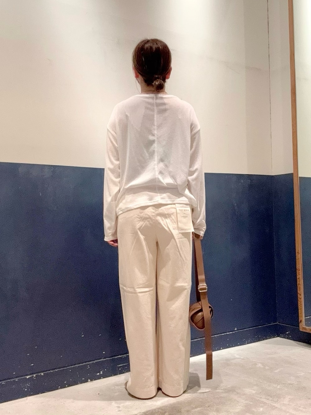 ホワイト系のデニムパンツ、ブラウン系のショルダーバッグ、ゴールド系のサンダルを着用したレディースの夏コーディネートの3枚目の写真