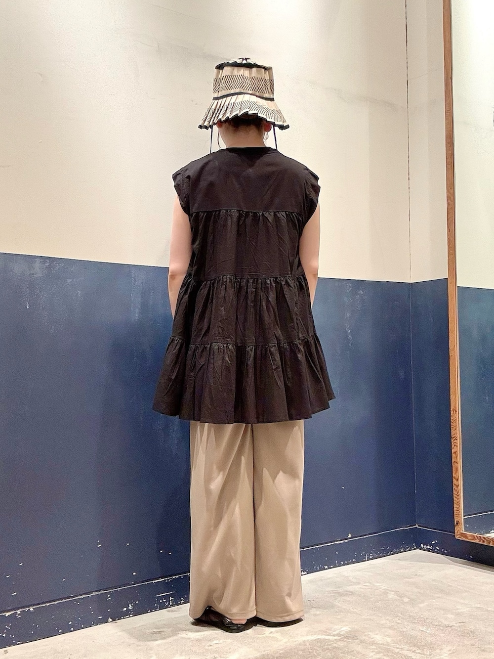 ブラック系のシャツ/ブラウス、ベージュ系のスラックス、ブラック系のパンプスを着用したレディースの夏コーディネートの3枚目の写真