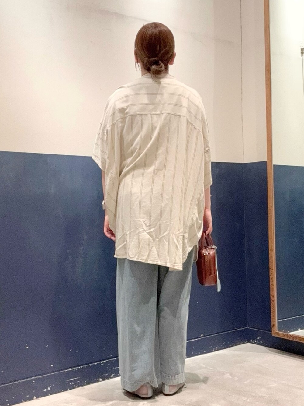 ベージュ系のシャツ/ブラウス、ブルー系のデニムパンツ、ブラウン系のトートバッグを着用したレディースの夏コーディネートの3枚目の写真