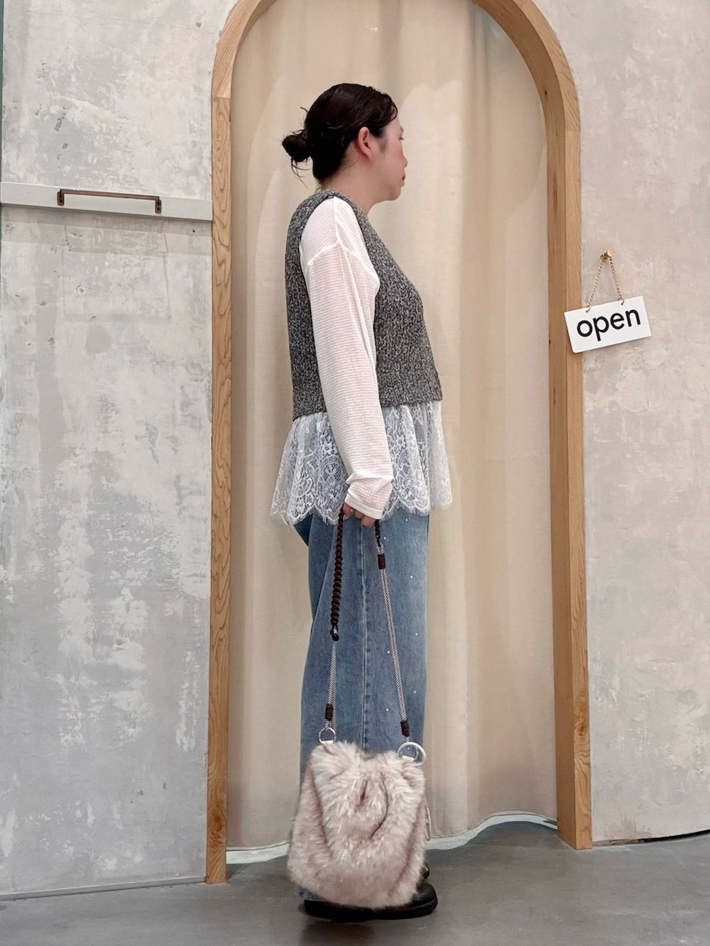 ブルー系のデニムパンツ、ベージュ系のトートバッグ、ホワイト系のTシャツ/カットソーを着用したレディースの秋コーディネートの2枚目の写真