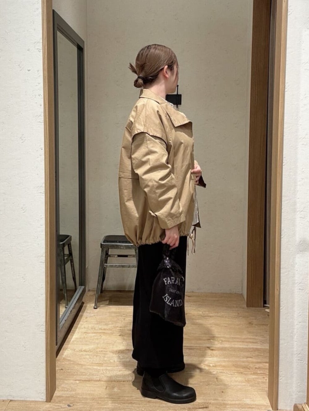 ブラック系のスカート、ベージュ系のトレンチコート、ブラウン系のシャツ/ブラウスを着用したレディースの春コーディネートの2枚目の写真