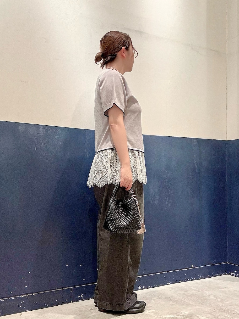 ブラック系のショルダーバッグ、ブラック系のデニムパンツ、グレー系のニット/セーターを着用したレディースの夏コーディネートの2枚目の写真