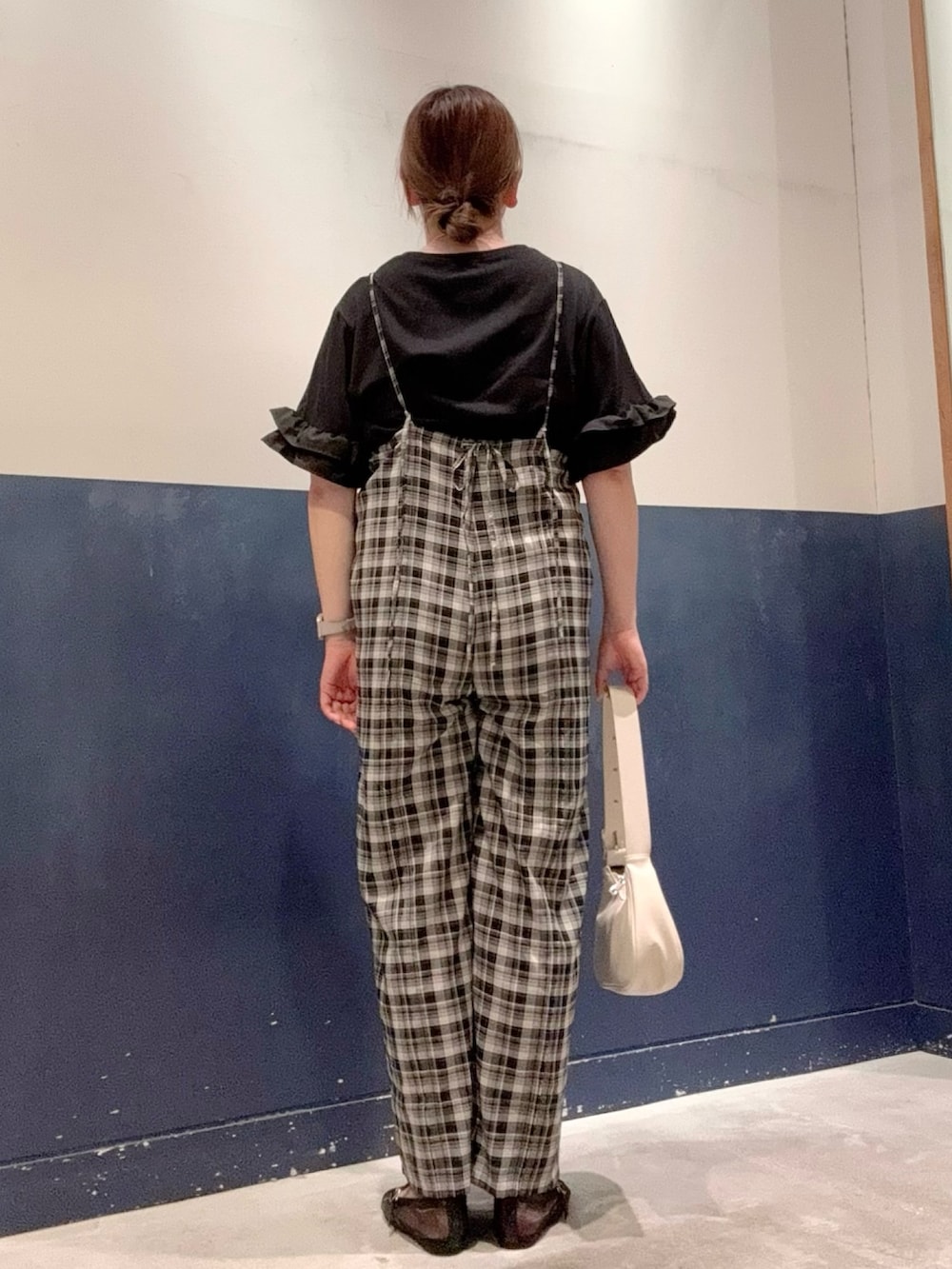 ホワイト系のトートバッグ、ブラック系のパンプス、ブラック系のTシャツ/カットソーを着用したレディースの夏コーディネートの3枚目の写真