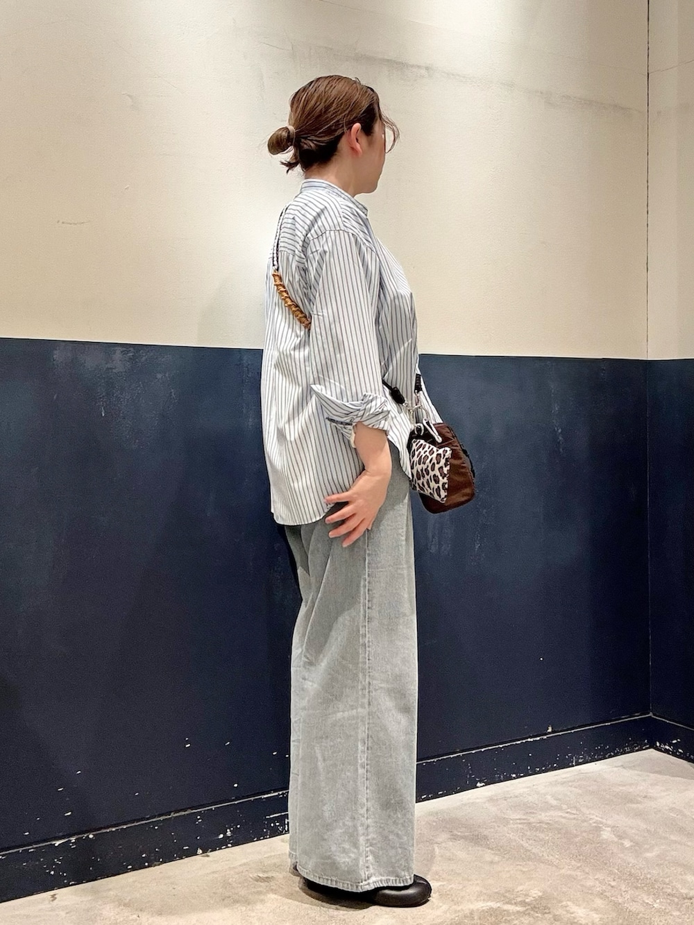ブラウン系のショルダーバッグ、ブルー系のデニムパンツ、ブルー系のシャツ/ブラウスを着用したレディースの春コーディネートの2枚目の写真