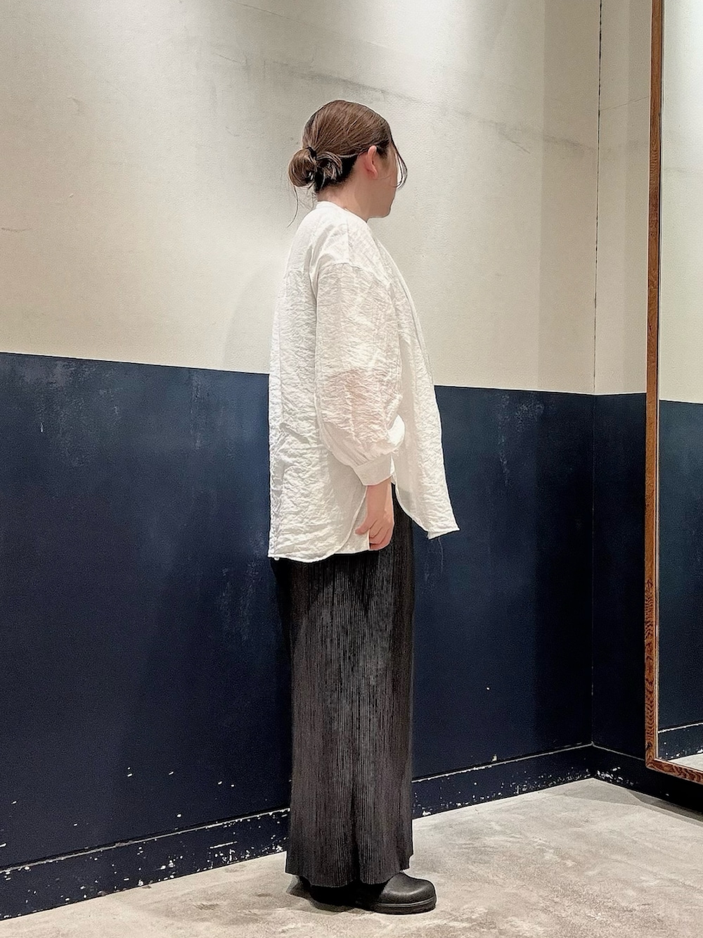 ブラック系のスカート、ホワイト系のTシャツ/カットソー、ホワイト系のシャツ/ブラウスを着用したレディースの春コーディネートの2枚目の写真