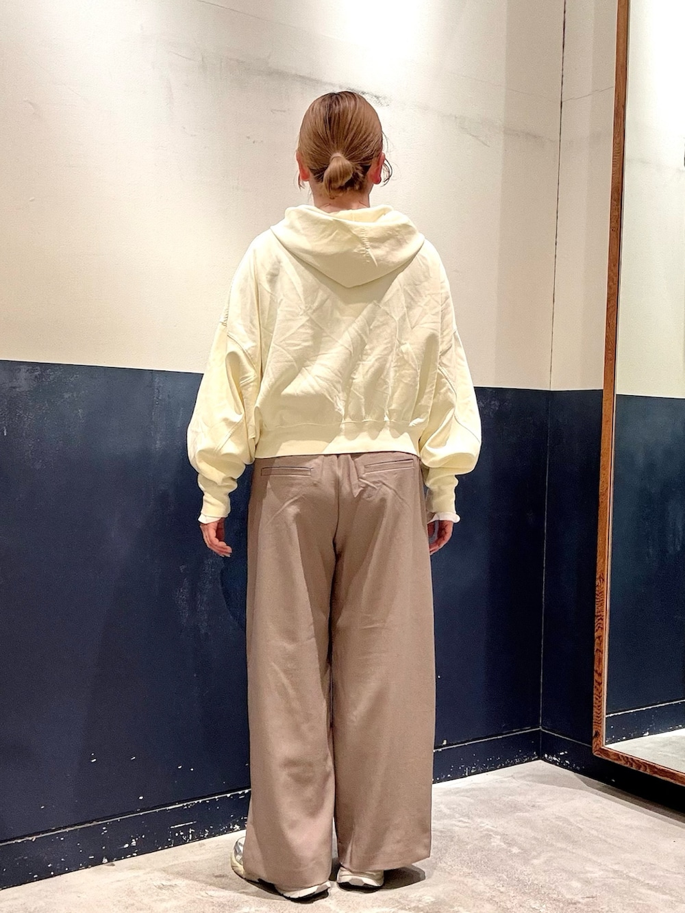 ベージュ系のスラックス、イエロー系のパーカー、ホワイト系のTシャツ/カットソーを着用したレディースの春コーディネートの3枚目の写真