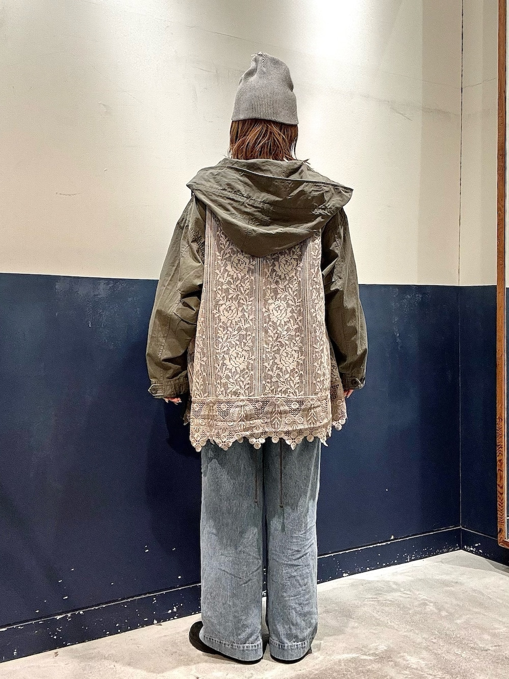 ホワイト系のニット/セーター、グリーン系のその他アウター、ブルー系のデニムパンツを着用したレディースの冬コーディネートの3枚目の写真