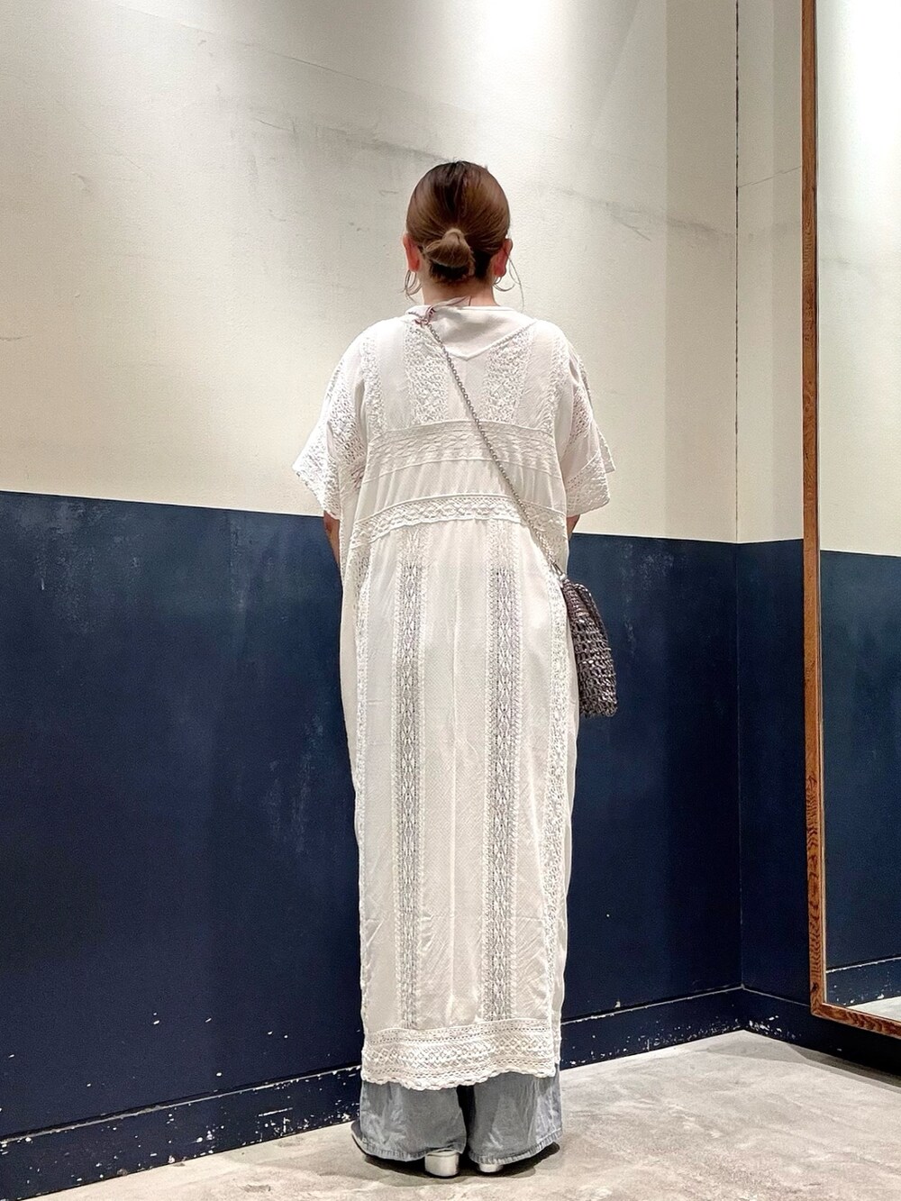 ホワイト系のワンピース、グレー系のショルダーバッグ、ブルー系のデニムパンツを着用したレディースの夏コーディネートの3枚目の写真