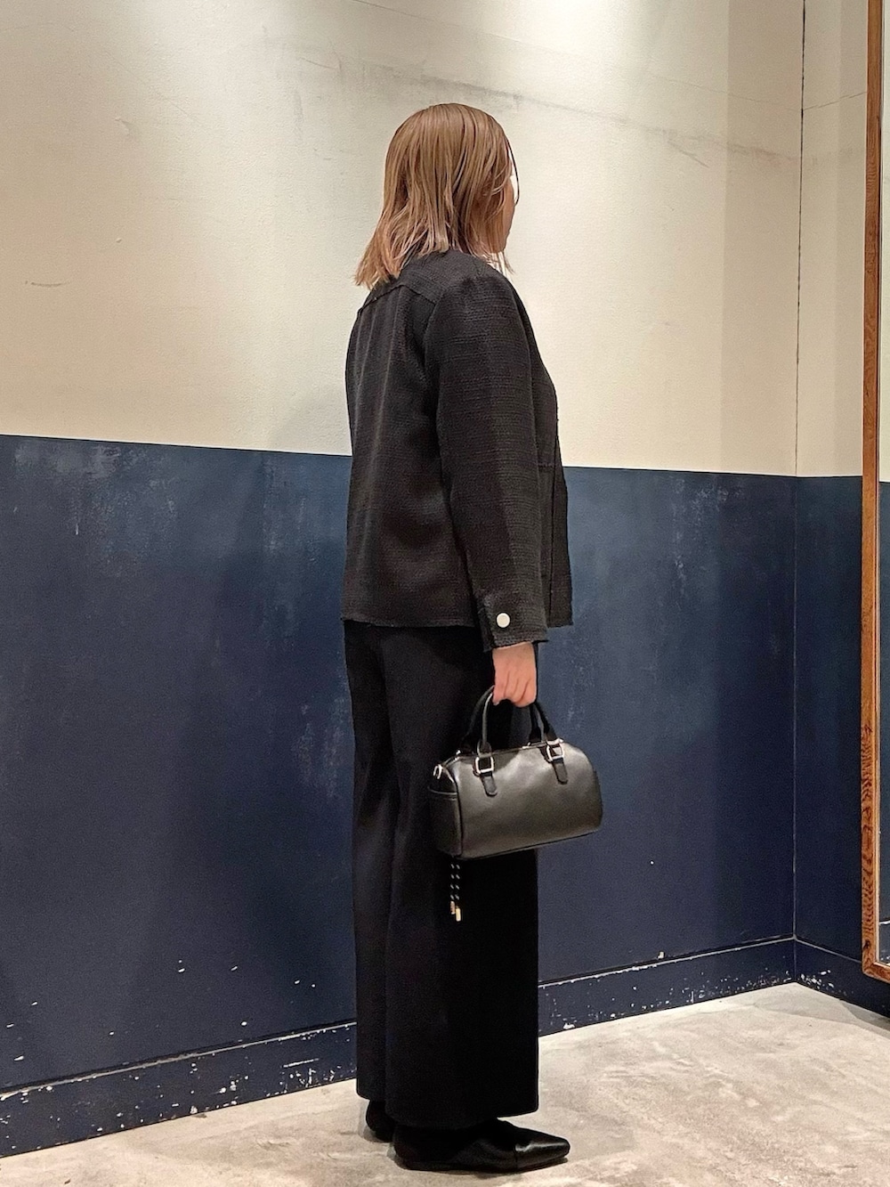 ブラック系のパンプス、ブラック系のショルダーバッグ、ブルー系のサロペット/オーバーオールを着用したレディースの冬コーディネートの2枚目の写真