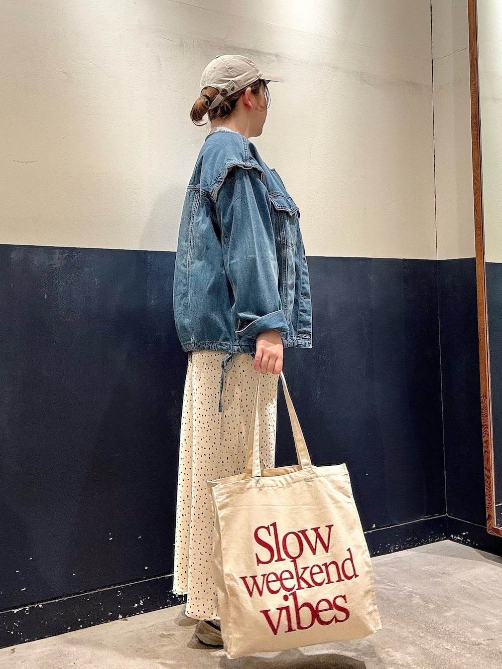 グレー系のニット/セーター、ブルー系のデニムジャケット、ホワイト系のスカートを着用したレディースの春コーディネートの2枚目の写真